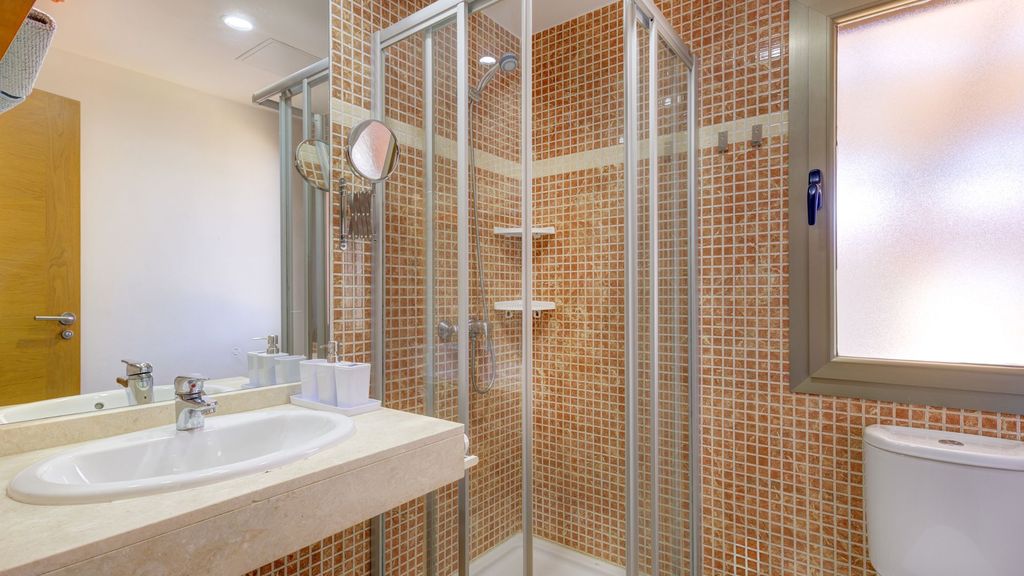 Baño de la villa con plato de ducha, lavabo y gresite